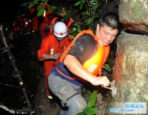 7月11日晚，一名网名叫“烟花”的游客（右一）在救援人员的帮助下走出峡谷