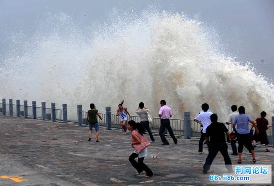 7月25日，在浙江海宁老盐仓沿岸，钱塘江潮水涌向岸堤，掀起巨浪。