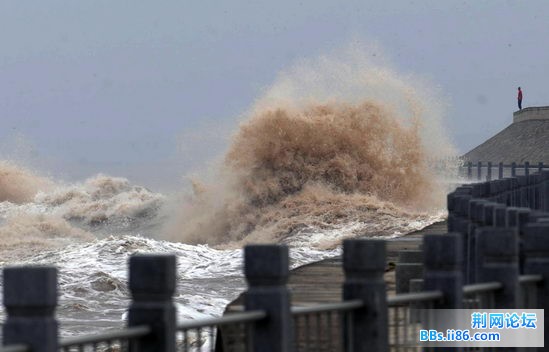 钱塘江潮水涌向岸堤，掀起巨浪。