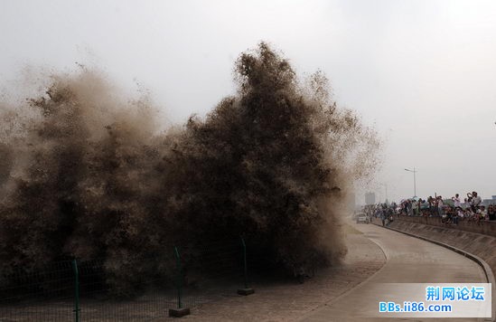 7月25日，浙江海宁，钱塘江潮水涌向岸堤，掀起巨浪